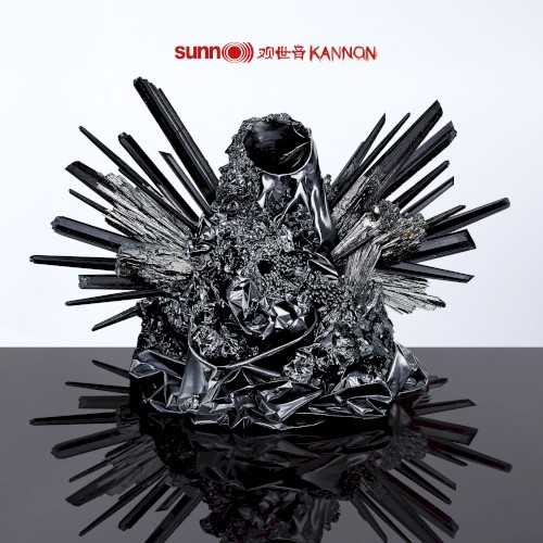 Allmusic album Review : When is nothing something? When is empty full? Kannon, Sunn O)))s first "solo" project since 2009s Monoliths & Dimensions, poses these questions sonically. Stephen OMalley and Greg Anderson enlisted old friends to assist: Co-producer Randall Dunn (who also plays synths), vocalist Attila Csihar, guitarist Oren Ambarchi, percussionist Brad Mowen, Rex Ritter on Moog, and a brass trio that includes Julian Priester, Stuart Dempster, and Tony Moore. The album title is named for the feminine Buddhist deity of mercy, Kanon (or Quan Yin), who "perceives all the sounds and cries of the world." (In the Tibetan male form, she is the bodhisattva Avalokiteśvara, who embodies the compassion of all Buddhas.) Kannon is structured as a three-part, numbered "triadic whole." Artist and theorist Aliza Shvarts, in her lengthy, soundly argued liner essay, describes them thusly: "Kannon 1": Invocation, "Kanon 2": Intonation, and "Kanon 3": Perpetuation. She brilliantly argues the question: "What is metal about mercy?" and proceeds to critique the notion of metals power as not merely penetrative but immersive -- this album is most certainly the latter. "Kanon I" offers Andersons earth quaking bass in full, dirty drone as OMalleys guitar repeats an ascending and descending three-note pattern. Csihar whispers, groans, and quietly growls poetic lyrics inspired directly by the Buddhist legend so elastically and deliberately, they are almost impossible to distinguish. Emanating from a wall of white noise, they entwine their heaviness with layers of massive ambient sound from synths and low brass. "Kannon 2" commences with squalling guitar feedback and raw, single guitar notes played in a pattern of four that repeat in reverse "choruses." The overblown bass drone enters at two-and-a-half minutes, and Csihar delivers his lyrics first in a Gregorian chant style that represents a "canonical" or traditional structure which, as Shvarts critiques, is itself a linguistic term that equates with Western male power structures. But Csihar then shifts (effortlessly) to Eastern throat singing, a folk style shared by sheepherders and monks alike. Sunn O))) turn the musics amplified power back on itself to allow his voices not only presence but fluidity. That cooperative flow is broken by the sound of a violent explosion that gives way to a sarod-esque drone. The effect is unsettling. "Kannon 3" is a studio version of "Canon" from 2008s live album Dømkirke. OMalleys piercing two-note theme harmonically registers with the powerful synth and a rumbling bassline. Along with waves of controlled noise, Csihars guttural vocal builds with the music until hes shrieking apocalyptically. The instrumental attack remains nearly glacial while its intensity increases exponentially. Large swathes of formless noise flow through the crashing waves until a final swell of feedback consumes it all until it blacks out. On Kannon, Sunn O))) illustrates through heavy sonic immersion that noise and silence are equals -- aspects of circular, self-perpetuating emptiness. Like the persona of the deity, they generously receive and contain all the sounds of the world in all their dimensions of darkness and light. kannon